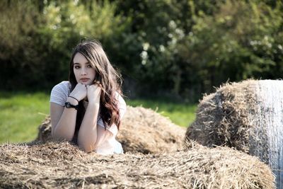 Portrait of young woman sitting on field