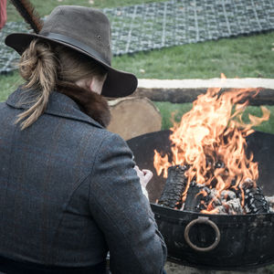 Rear view of woman standing by fire