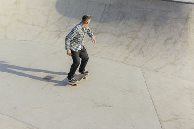 Man skateboarding on ramp in park