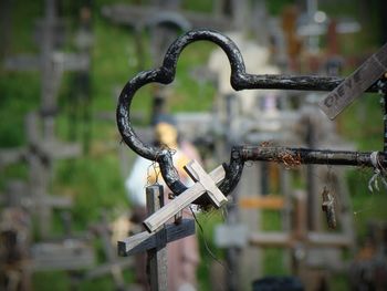 Close-up of crosses hanging on metal in cemetery