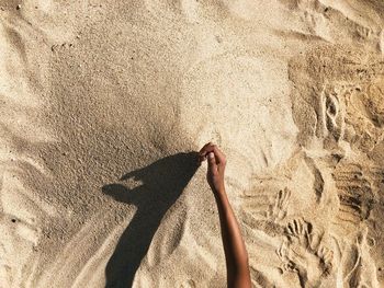 Shadow of hand on sand