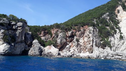 Rocks by sea against sky