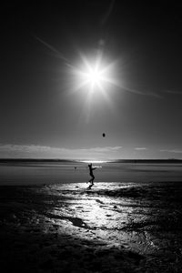 Silhouette person on beach against sky