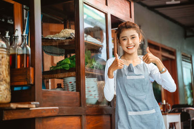 Portrait of smiling young woman standing in store