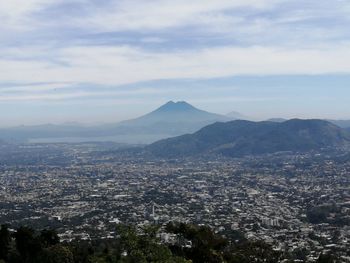 Aerial view of city and mountains against sky