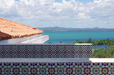 A close up view of part of a red tile roof, decorative tiles on the walls