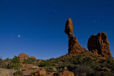 Low angle view of rock formations against blue sky at night