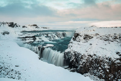 Scenic view of waterfall against sky during winter