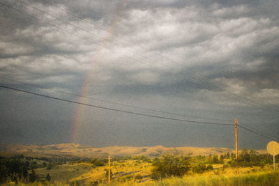 Electricity pylon on land against sky