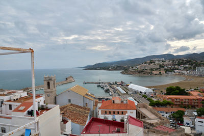 High angle view of townscape by sea against sky