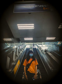 Full length of woman standing at illuminated station