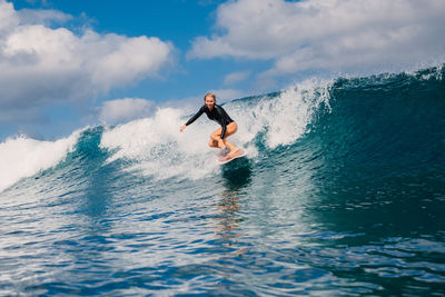 Man surfing in sea against sky