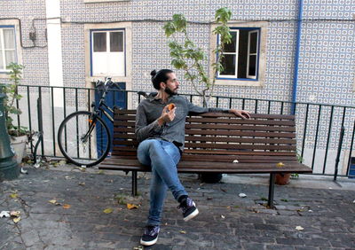 Man having food while sitting on bench