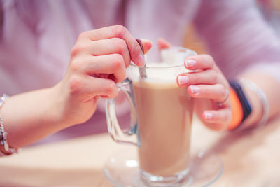 Midsection of woman having coffee