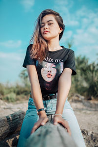 Portrait of young woman sitting on field