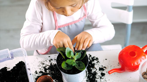 High angle view of girl planting on table