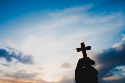 Low angle view of silhouette cross against sky during sunset