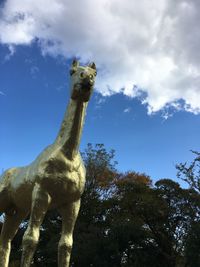 Low angle view of statue on tree against sky