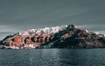 Scenic view of sea by rock formation against sky