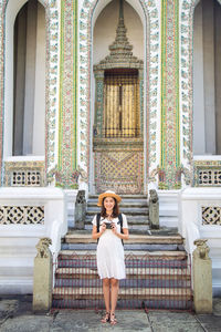 Portrait of woman standing against building