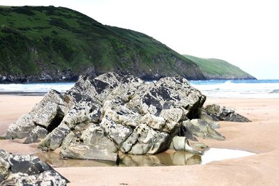 Rocks on beach against sky