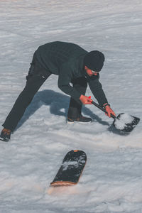 Low section of man skiing on snow covered field