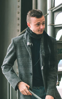 Young man standing at railroad station