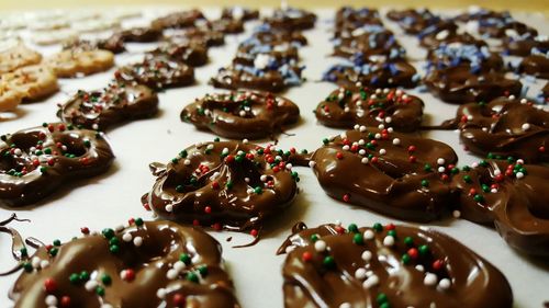 Preparation of chocolate and sprinkles covered pretzels on wax paper