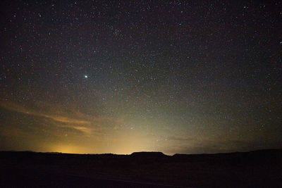 Silhouette landscape against sky at night