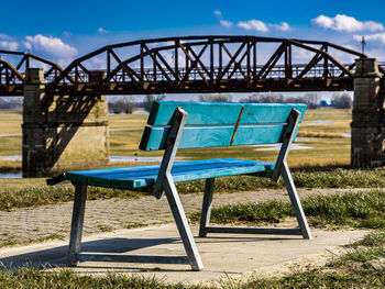 Empty bench against blue sky