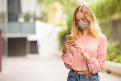 Full length of woman holding mobile phone