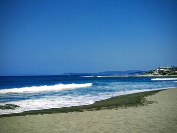 Scenic view of beach against clear blue sky