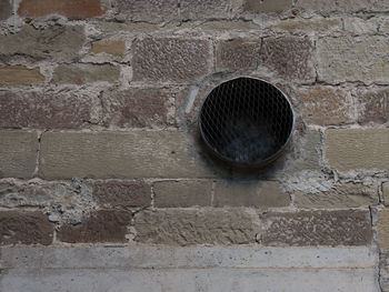Close-up of manhole on brick wall
