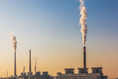 Smoke emitting from chimney against sky