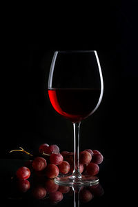 Red wine glass against black background