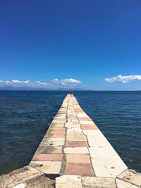 Scenic view of pier on sea against blue sky