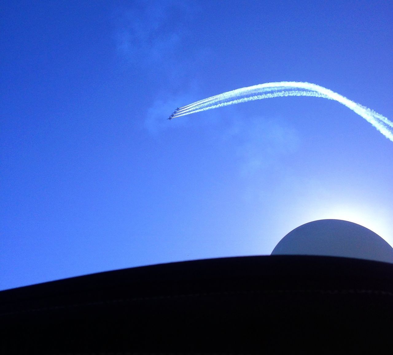 blue, clear sky, copy space, low angle view, flying, airplane, transportation, vapor trail, travel, air vehicle, mode of transport, mid-air, outdoors, journey, famous place, travel destinations, architecture, built structure, no people, part of