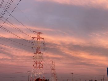 Low angle view of silhouette electricity pylon against sky during sunset