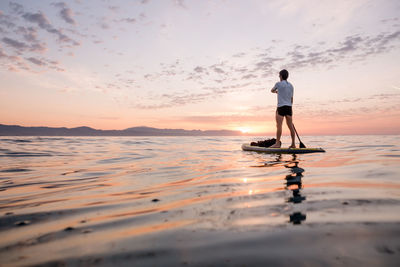 Concept, peace, calm and freedom. man paddling upright on the pa person