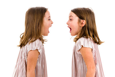 Side view of twin girls against white background