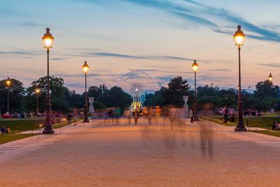 Blurred motion of people on footpath at jardin des tuileries during sunset