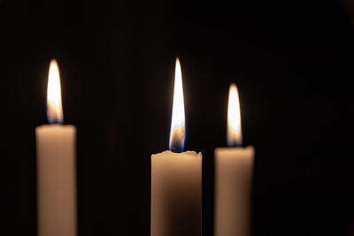 Close-up of candles burning in darkroom