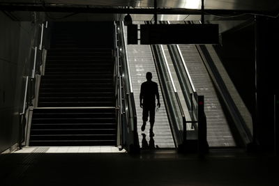 Rear view of men walking on staircase in building