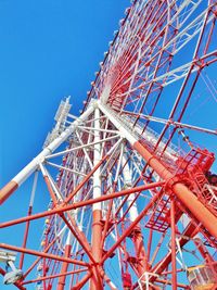 Low angle view of ferris wheel against clear blue sky