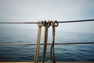 Close-up of ropes against calm sea