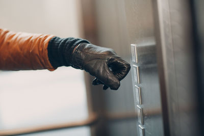 Close-up of hand holding glass container