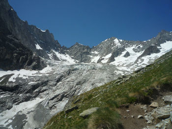 Scenic view of snowcapped mountains against clear blue sky