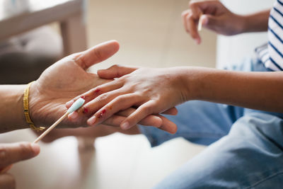 Parent helping her child perform first aid finger injury after she has been an accident.