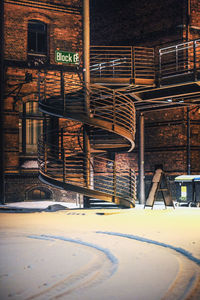 Snow covered house against buildings in city