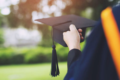 Close-up of hand holding mortarboard